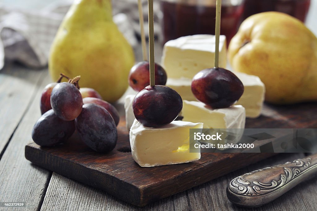 Canape with camembert Canape with camembert cheese and grape on wooden background Appetizer Stock Photo