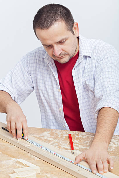 istock Woodwork - man measuring wooden planck 462381843