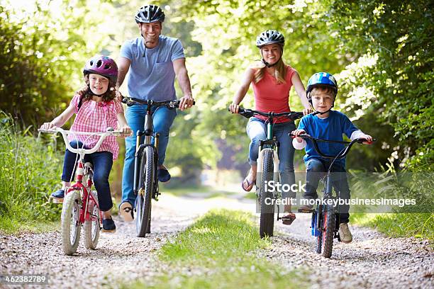 Family Of Four Riding Bikes On Gravel Road Stock Photo - Download Image Now - Family, Cycling, Bicycle