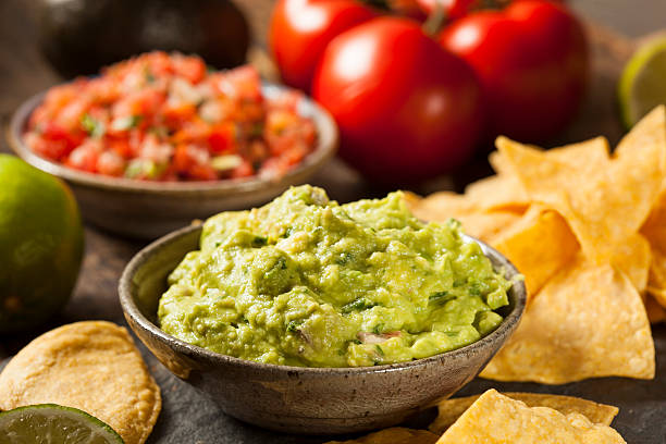 Green Homemade Guacamole with Tortilla Chips Green Homemade Guacamole with Tortilla Chips and Salsa guacamole photos stock pictures, royalty-free photos & images