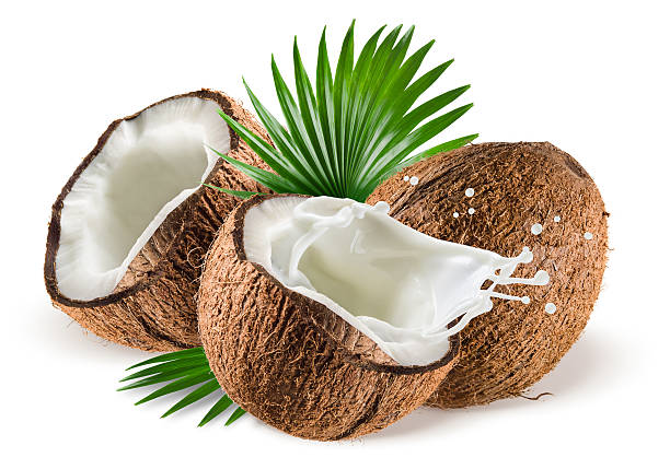 istock Whole and cut coconuts with milk splashing and green leaves 462396309