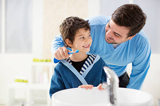 fröhlich vater und sohn bürsten zähne im badezimmer. - child brushing human teeth brushing teeth stock-fotos und bilder