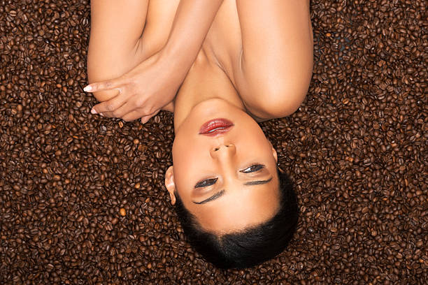 Attractive woman lying upside down on coffee seeds.