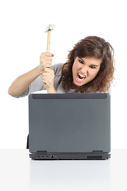 istock Angry woman destroying a computer with hammer 462403531