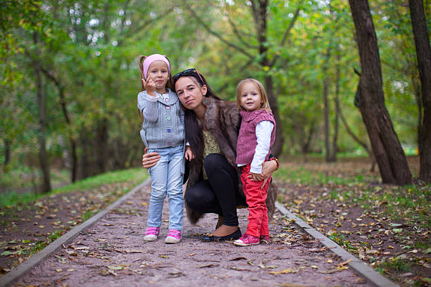 istock Young mother with her little daughters looking to camera oudoor 462405193