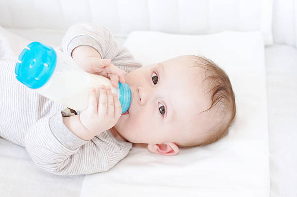 istock baby with small bottle in bed 462406101