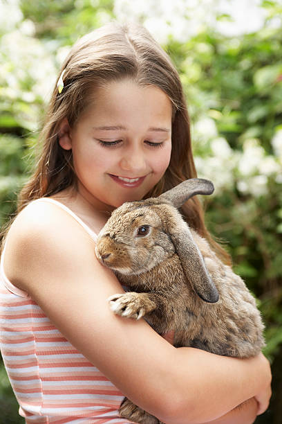 istock Young girl smiling at her bunny rabbit 462411165