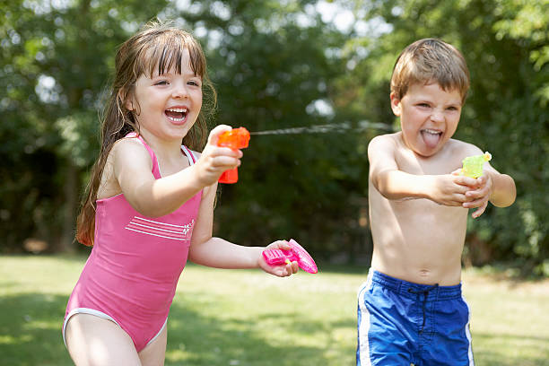 istock Cheerful Kids Shooting Water Pistols 462411415