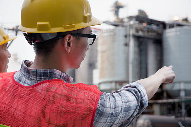 istock Two engineers in protective workwear pointing outside of a factory 462415605