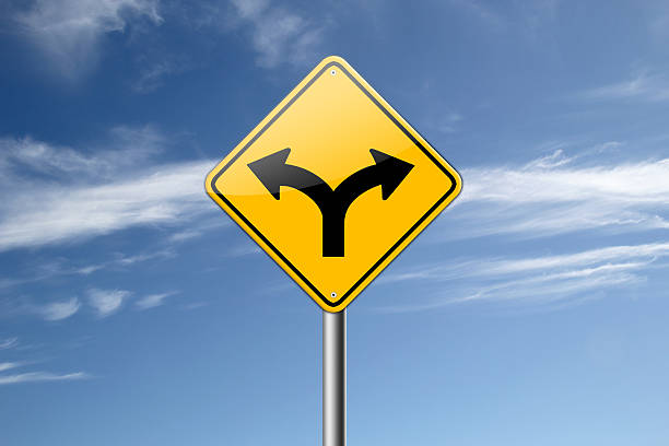 istock Yellow road sign showing forked road against a blue sky 462419915