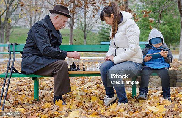 Boy Sitting Bench Holding Tablet Computer While His Mother Grandfather Stock Photo - Download Image Now