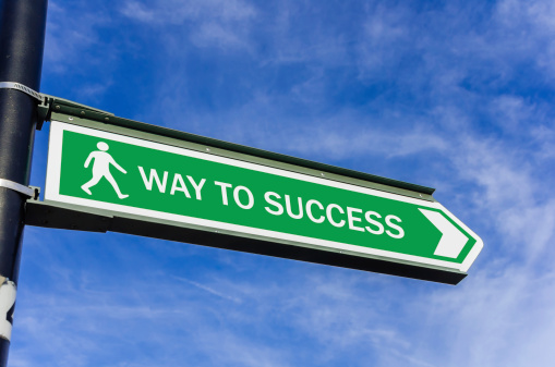Conceptual road sign on success against blue sky