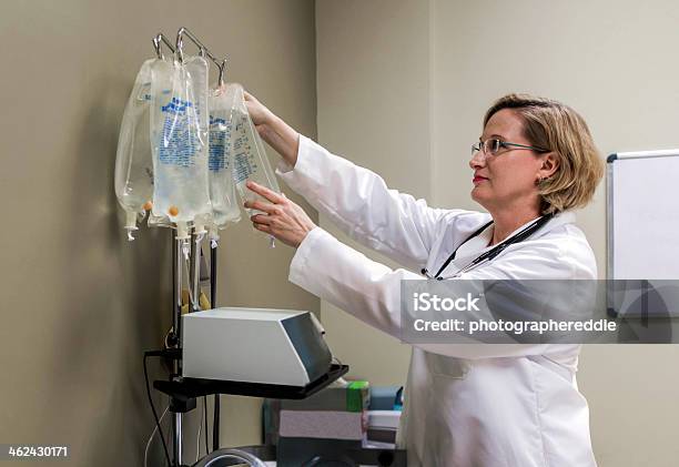 Doctor Revisando Iv Bolsa Foto de stock y más banco de imágenes de Bolsa - Objeto fabricado - Bolsa - Objeto fabricado, Gota a gota, Adulto