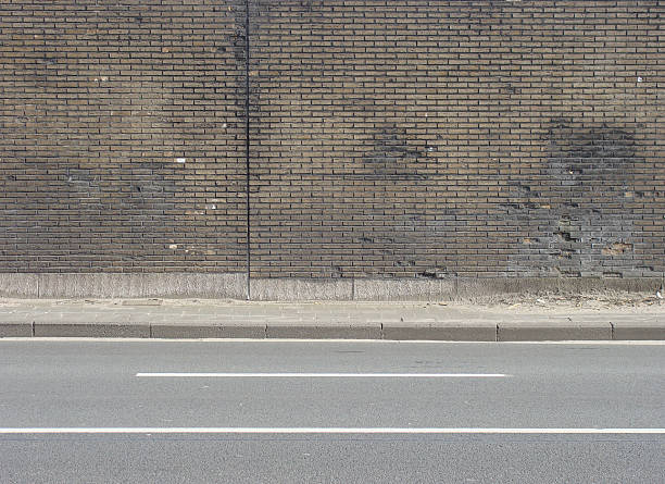 istock road,sidewalk and brown beige tiled worn wall 462439397
