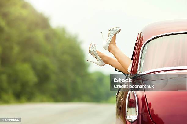 Woman Sticking Her Feet Outside Of A Classic Car Stock Photo - Download Image Now - Car, Love - Emotion, Shiny