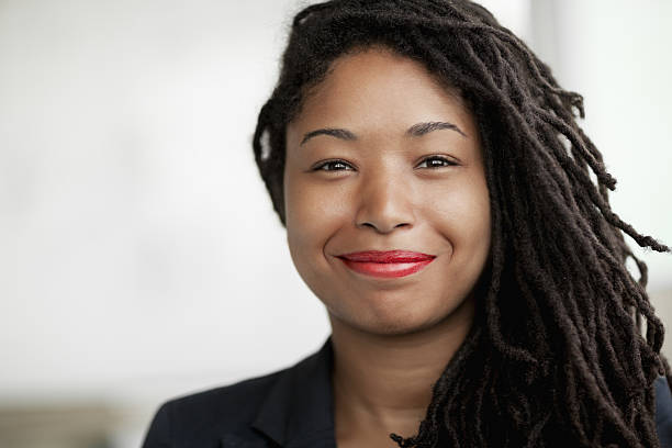 Portrait of smiling businesswoman with dreadlocks, head and shoulders stock photo