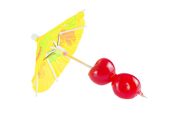 Cocktail cherry. Cocktail cherry on party parasol isolated on white background. maraschino cherry stock pictures, royalty-free photos & images