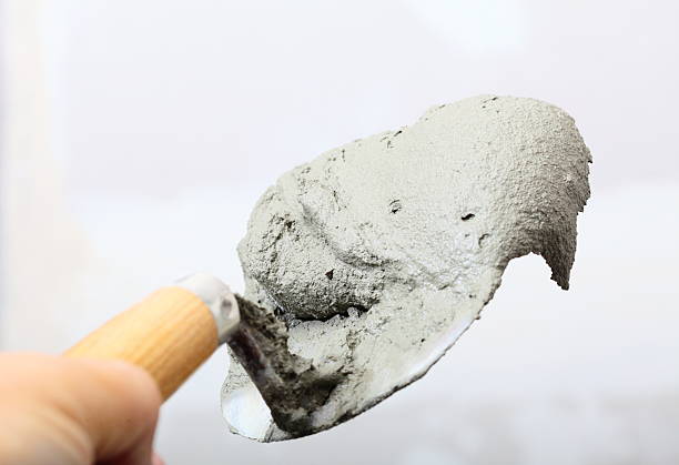 istock Hand holding a bucket trowel with cement mortar 462459291