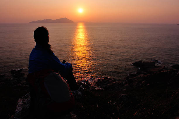 istock woman hiker sit on rock face the sunrise 462462725