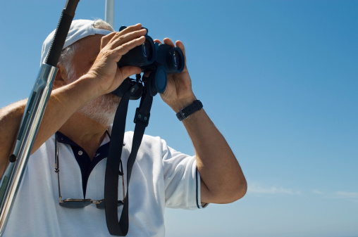 Captain of Racing Yacht Using Binoculars