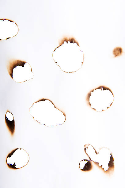 istock Burnt holes in paper 462469571