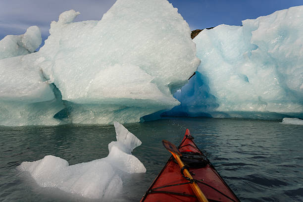 istock Kayak passes over edge of iceberg heading into ice field 462481205