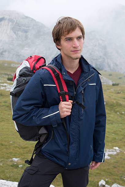 istock Young man hiking in the mountains with a backpack 462481419