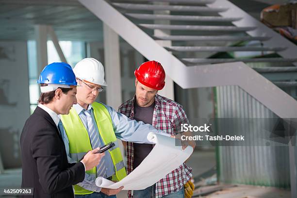 Construction Team Reviewing Blueprints Together Stock Photo - Download Image Now - Adult, Adults Only, Architect