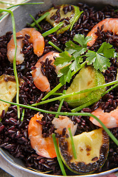 Presentation and preparation of black rice with zucchini and shrimps