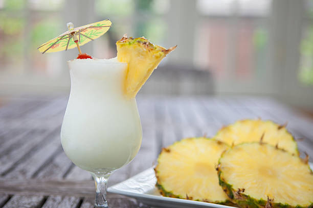 Pina colada with pineapple slices on wooden table