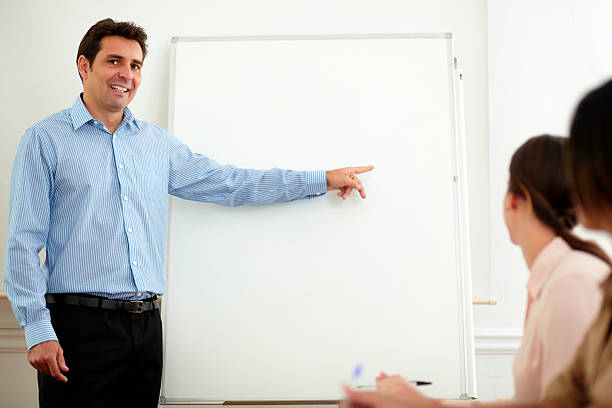 istock Handsome adult businessman pointing at whiteboard 462527231