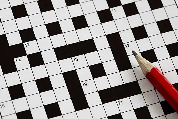 Solving a crossword puzzle with red pencil