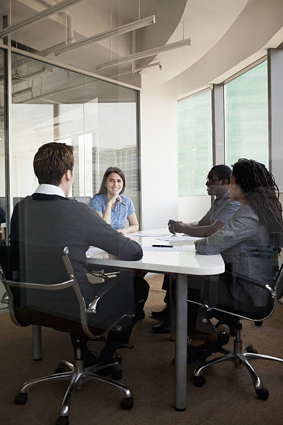 istock Four business people sitting at a conference table 462535885