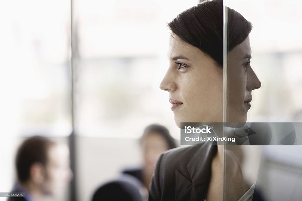 Side profile on a businesswoman with coworkers in the background Profile View Stock Photo