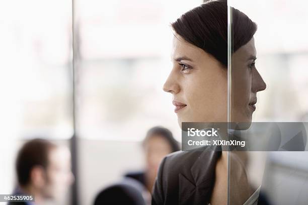 Side Profile On A Businesswoman With Coworkers In The Background Stock Photo - Download Image Now
