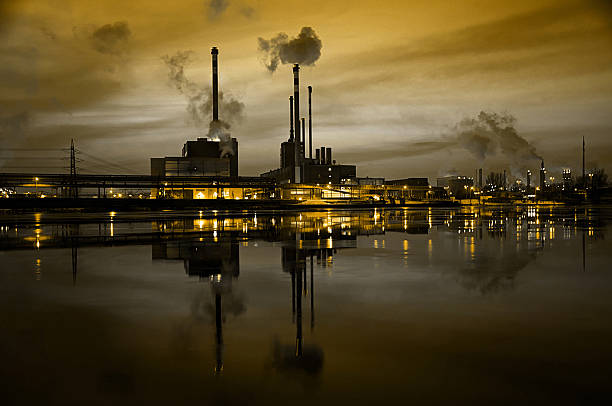 istock factory at night mirroring in the river 462537301