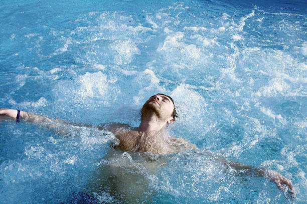A man relaxing in a pool of water stock photo