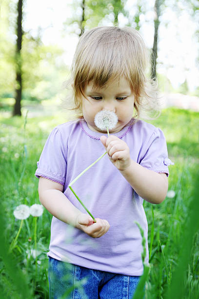 istock girl smelling dandelion 462540811