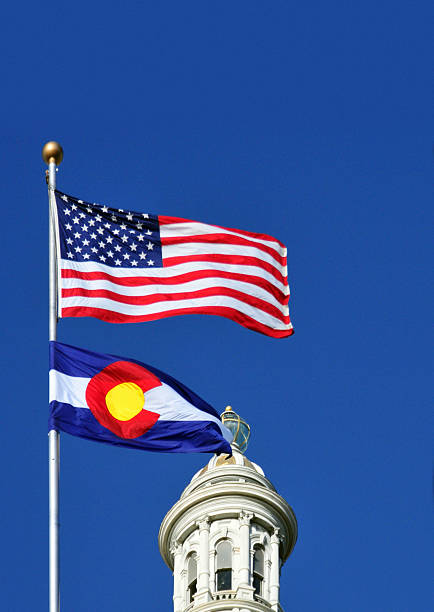 Denver, Colorado, USA: Colorado State Capitol - flags of Colorado and the US and the 24 karat gold plate dome - deep blue sky with copy space - photo by M.Torres
