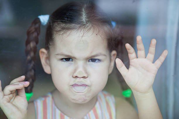 Girl misses at the window stock photo