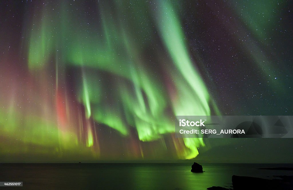 The Northern Lights Aurora Strong multi colored Aurora Borealis over the Atlantic Ocean. Aurora Polaris Stock Photo