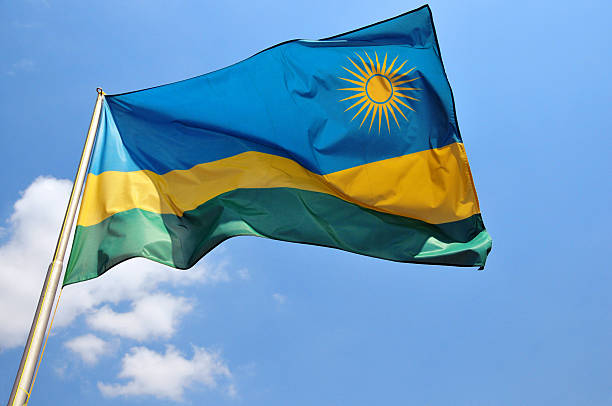 Rwandan flag (not computer generated) Kigali, Rwanda: Rwanda flag against blue sky - sun and blue, yellow and green stripes - photo by M.Torres rwanda stock pictures, royalty-free photos & images