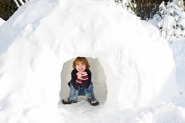 divertido niño jugando en la nieve iglú - iglú fotografías e imágenes de stock