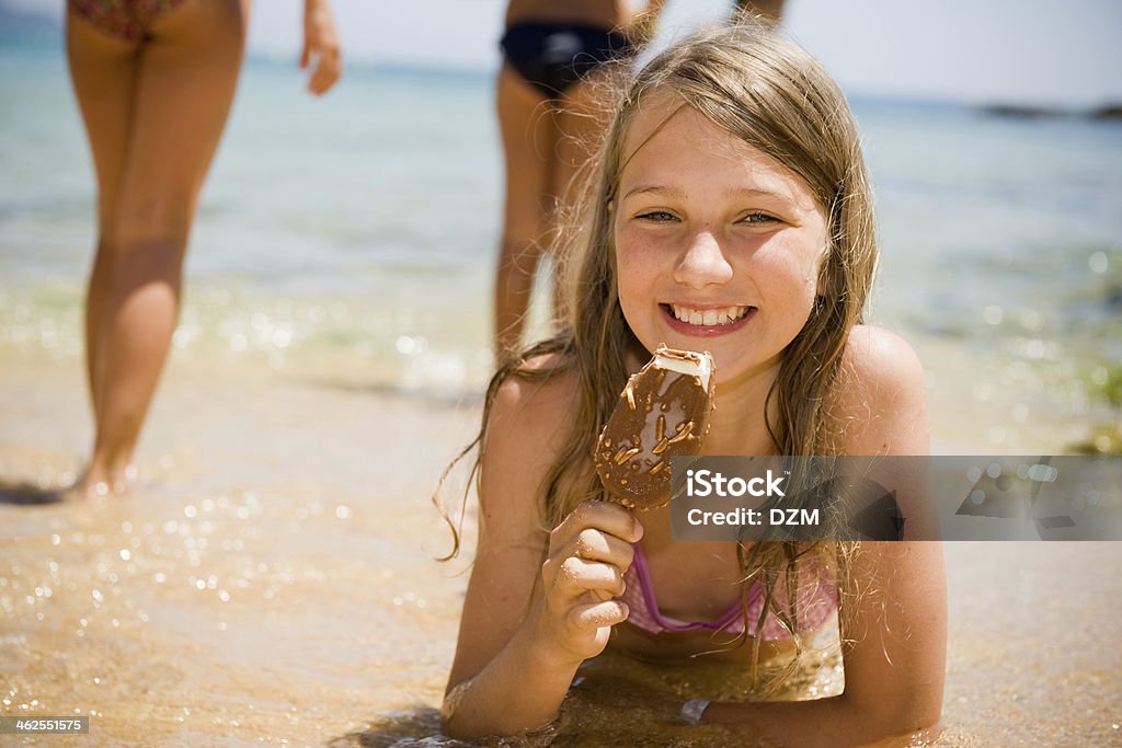 Summer holiday Portrait of child lying on the beach and eating ice cream Beach Stock Photo