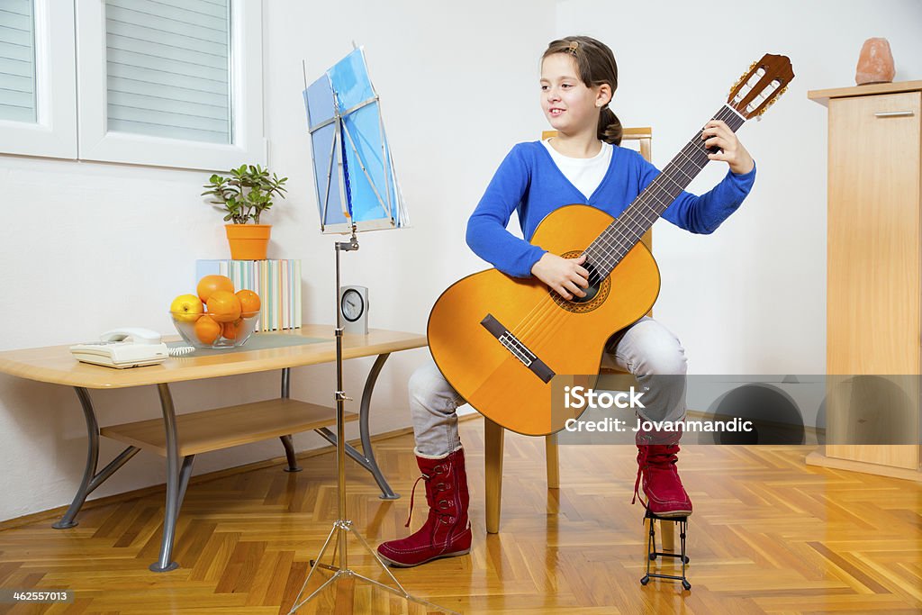 Young Girl Playing Guitar Young girl playing guitar 8-9 Years Stock Photo