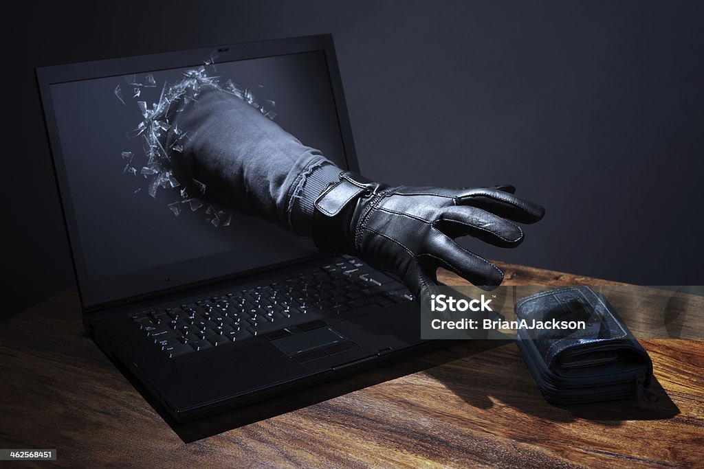 Internet crime and electronic banking security Stealing a purse through a laptop concept for computer hacker, network security and electronic banking security White Collar Crime Stock Photo