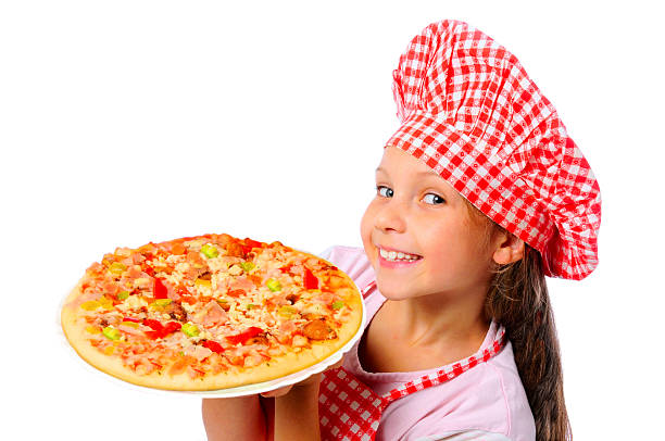 Young girl in a chef hat smiling and holding a pizza Young girl preparing homemade pizza gir forest national park stock pictures, royalty-free photos & images