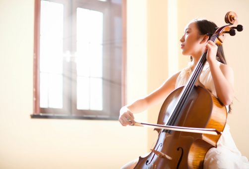 East asian teenage girl playing cello