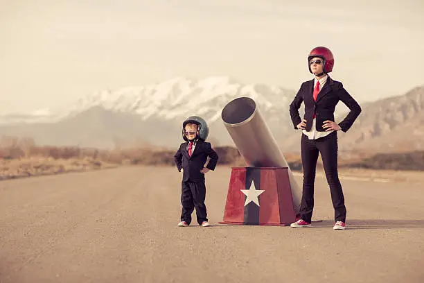 Photo of Young Boy and Woman Business Team with Human Cannon