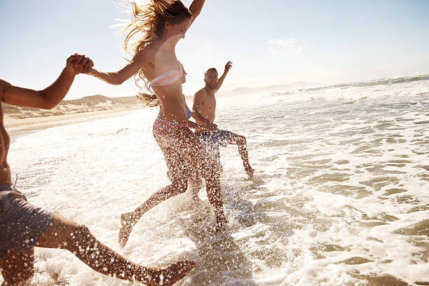 éclabousser dans les vagues - beach women swimwear summer photos et images de collection